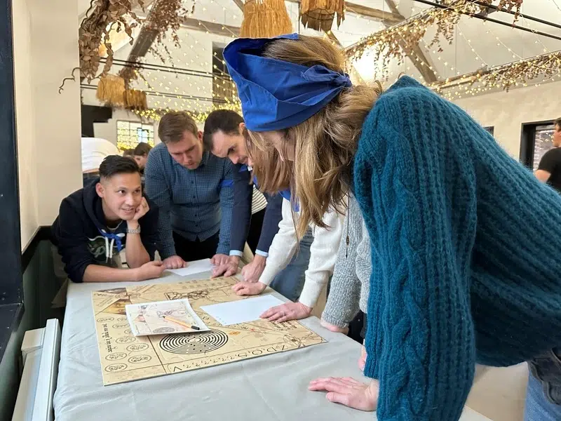 Jeu de cohésion d’équipe en entreprise autour d’un parchemin d’énigmes à reconstituer